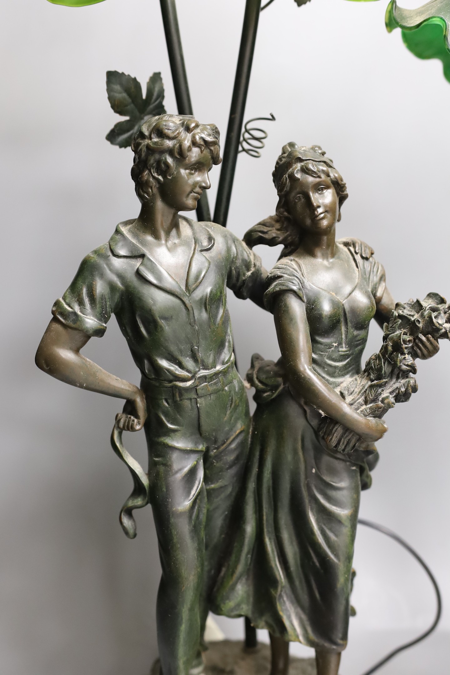 Two bronzed metal figural table lamps, with Art Nouveau style glass shades, 66cm total